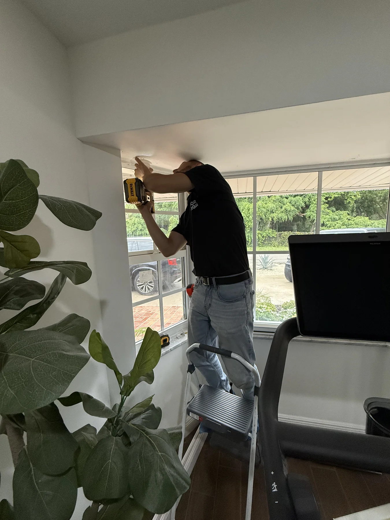 S&V Decor Design installer measuring and mounting hardware above a window