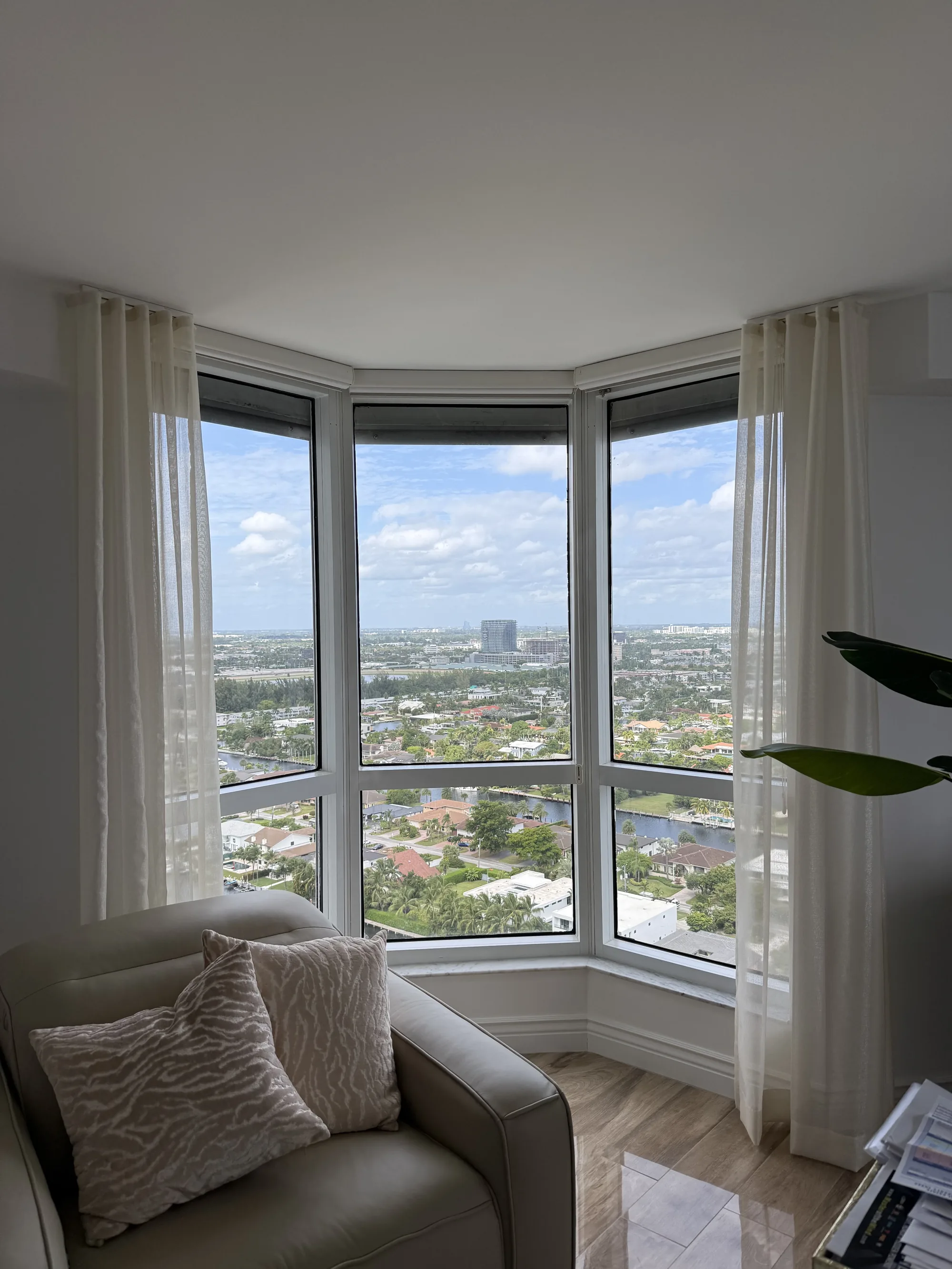 Drapery on a track system in a bay window with city views