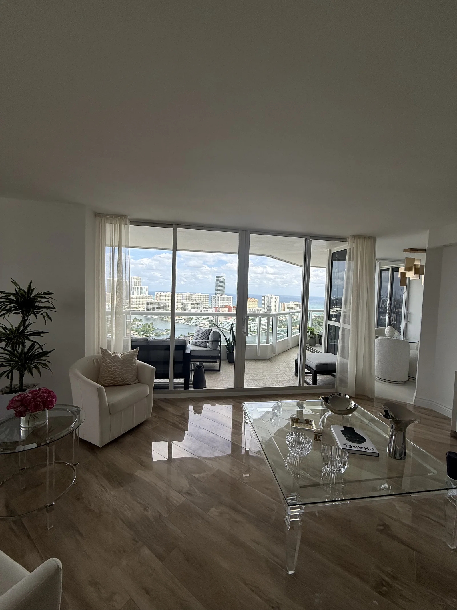 Sheer drapery framing floor-to-ceiling windows in a high-rise living room