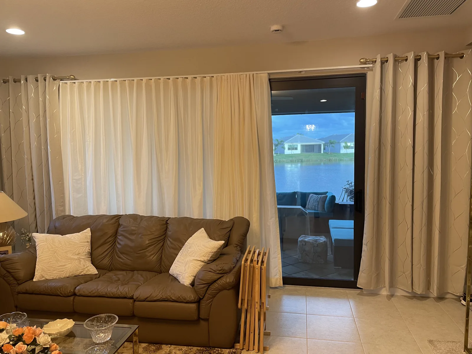 Drapery panels beside a sliding door with a water view