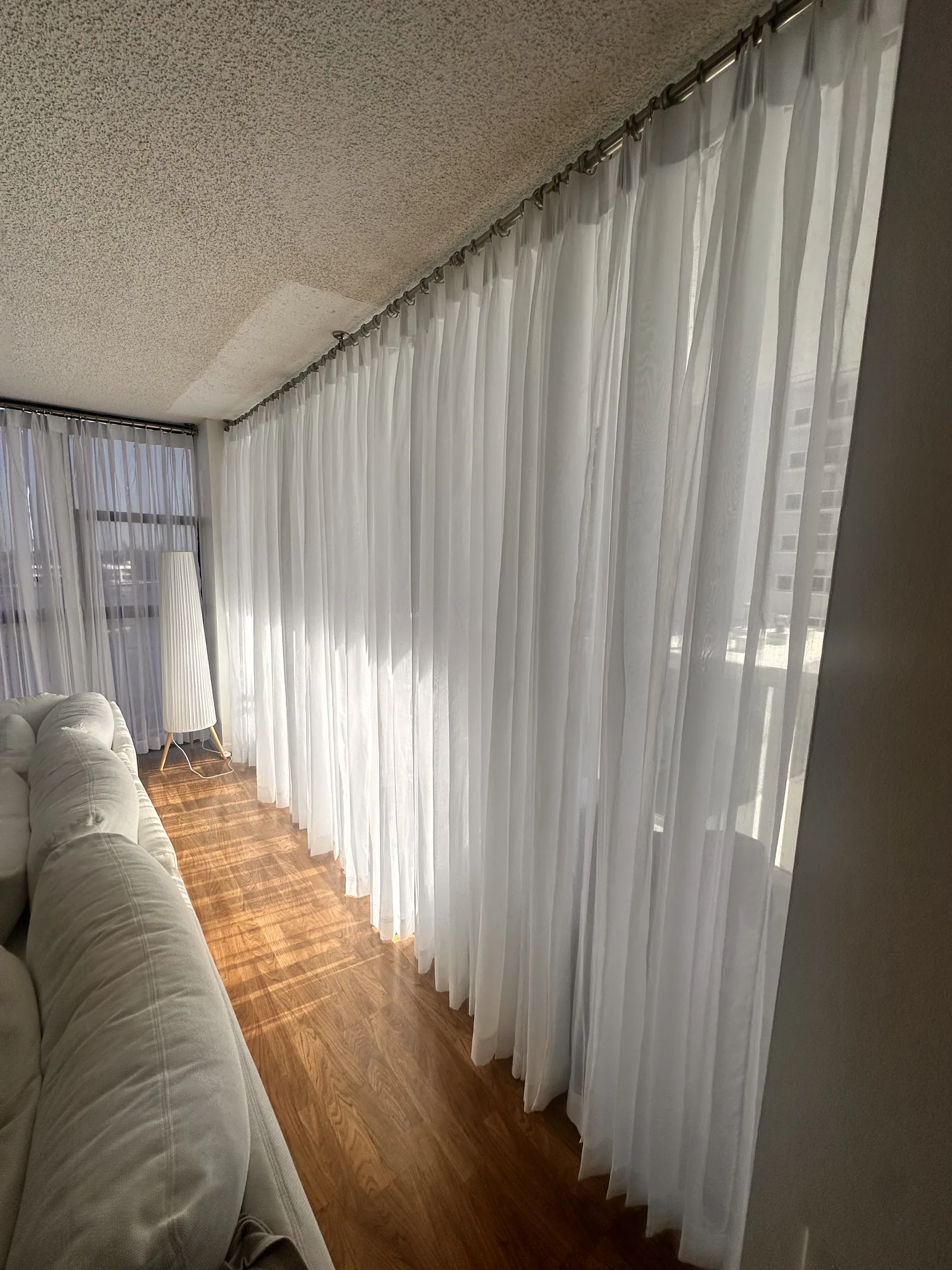 Sheer drapery running the length of a living room wall