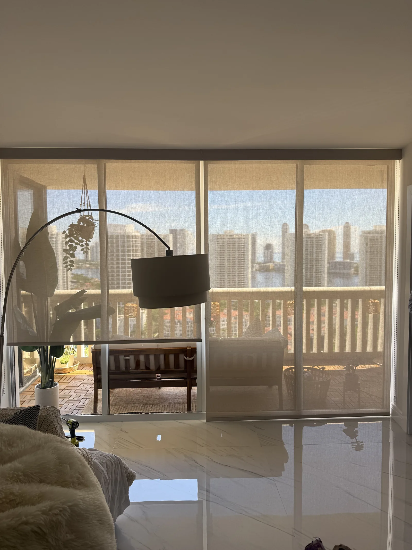 Roller screen shade on a balcony slider with a city view