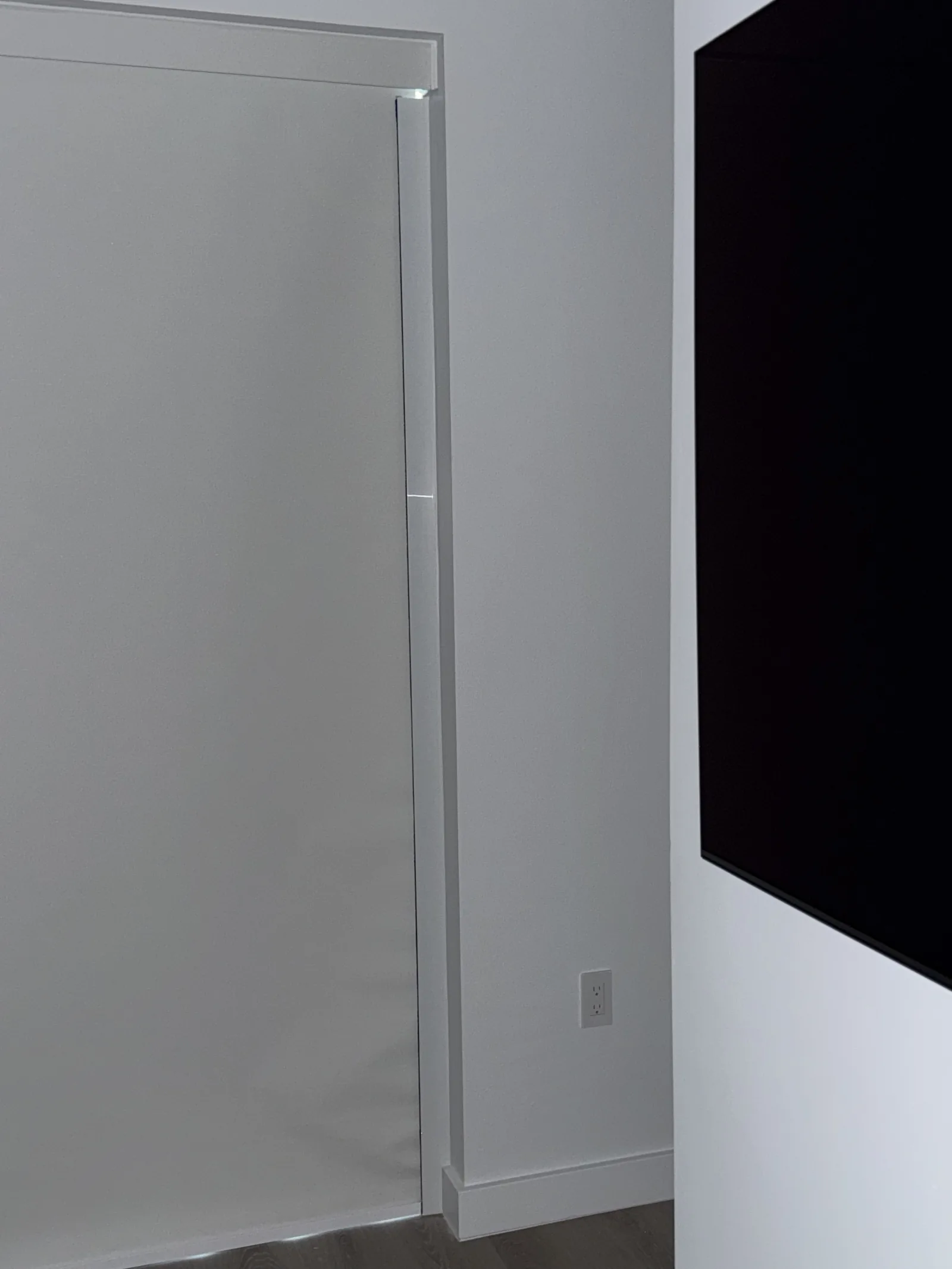 Blackout shade held flat by side channels on a tall window