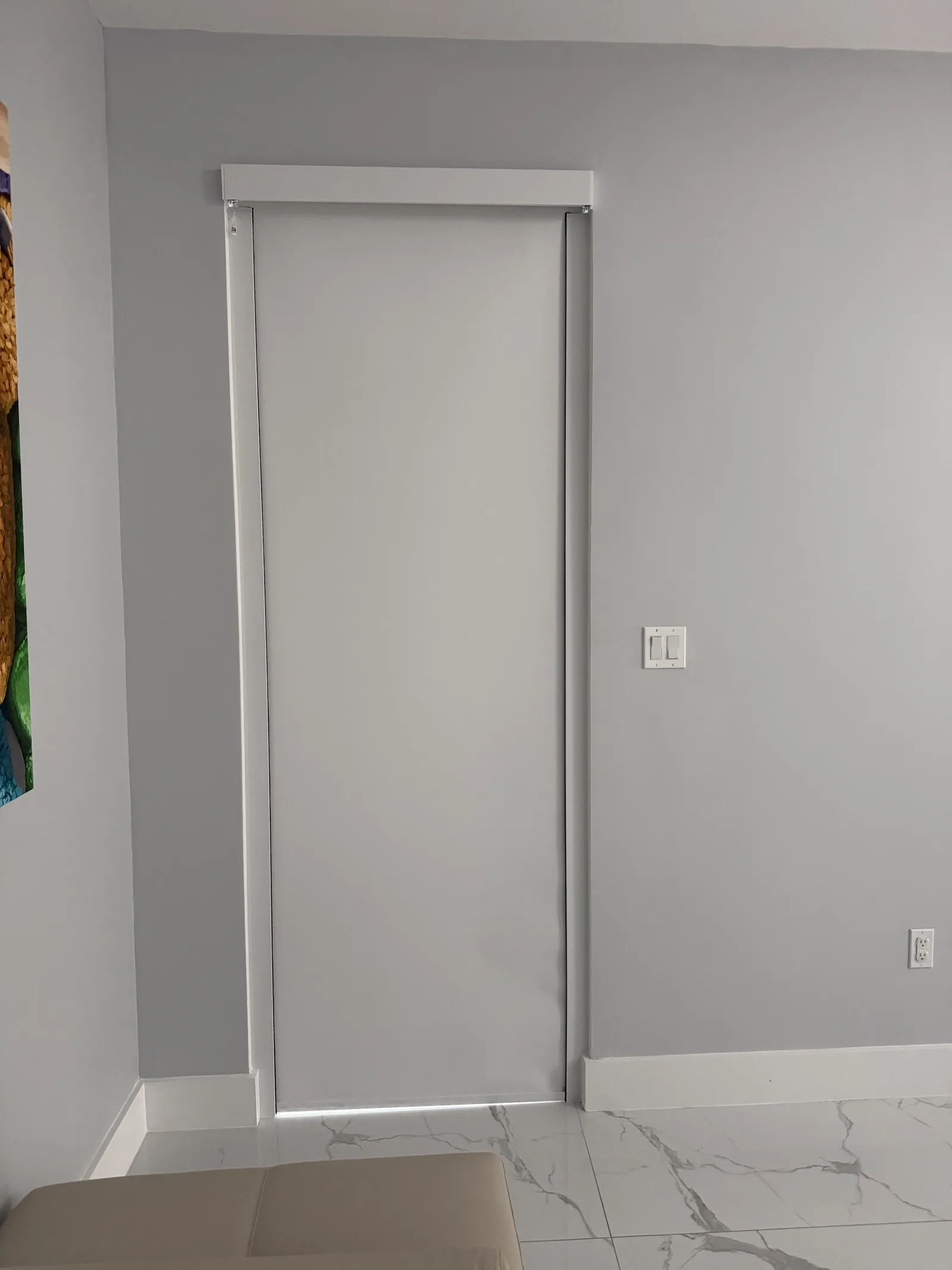 Blackout shade with side channels in a white bedroom
