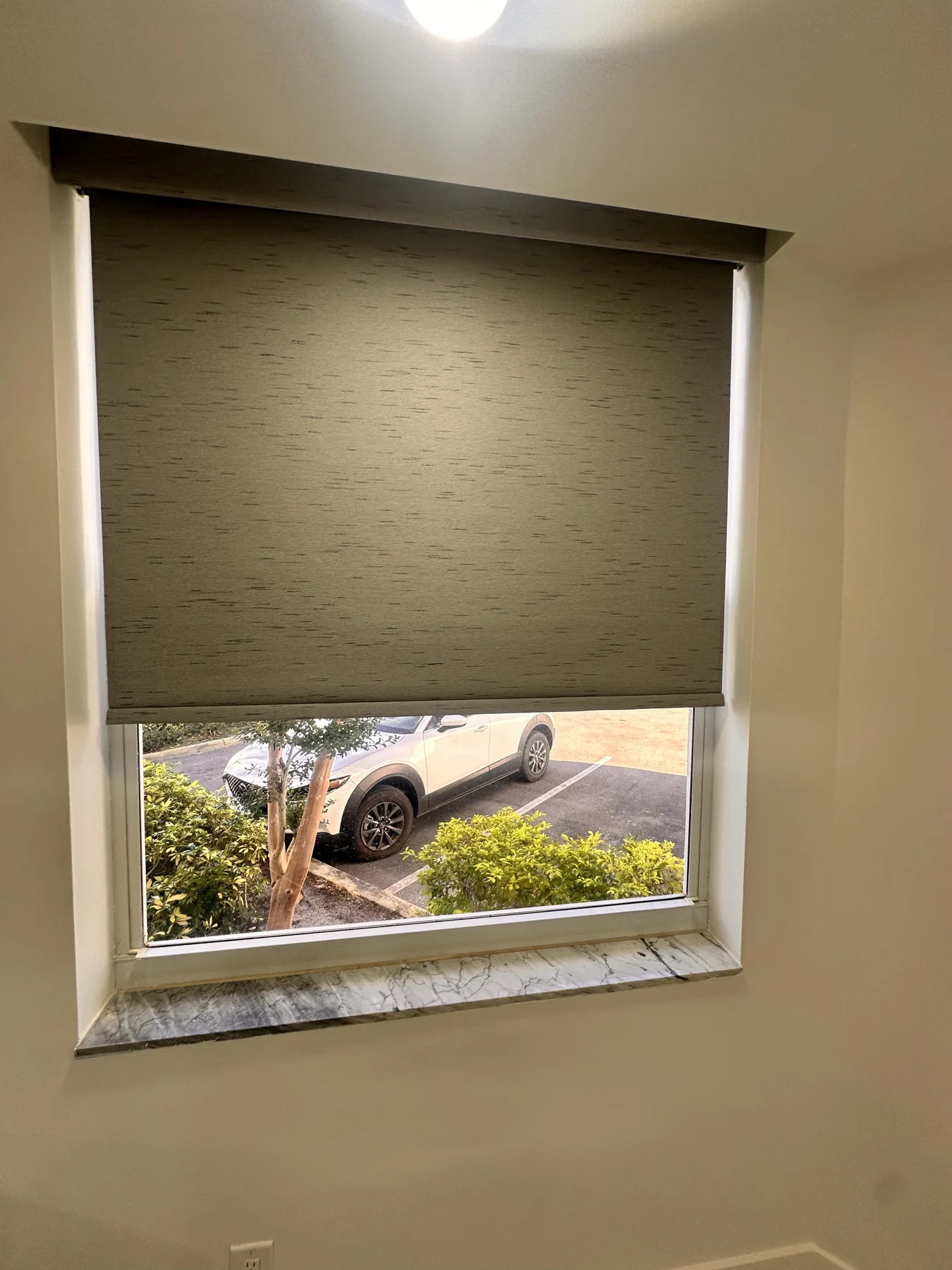 Blackout roller shade installed in a bedroom window