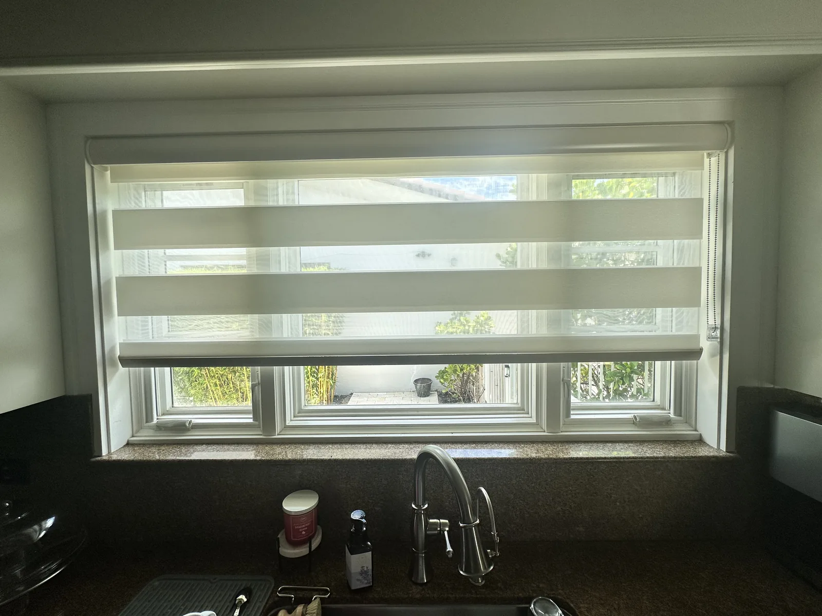Zebra light-filtering shade over a kitchen sink window
